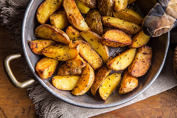 patata. patate arrosto. patate americane con sale pepe e cumino. - roasted potatoes prepared potato herb food foto e immagini stock