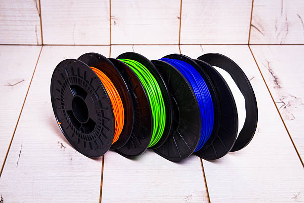 istock Side view of four colored 3D printer filament spools 622796996