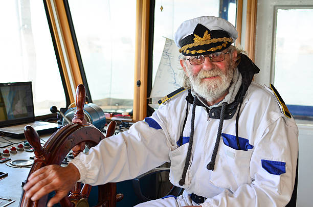 Ship navigation, experienced captain, old sea dog with grey hair and beard in ship navigation cabin, smiling and satisfied after well done job