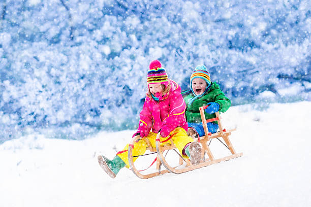 istock Kids having fun on sleigh ride in snow forest 622797454