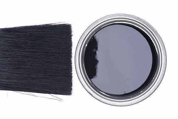 A low angle image of old dirty lids from used paint cans and one paint brush on an old work bench.