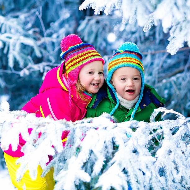 istock Kids twins playing in snowy forest 622799228