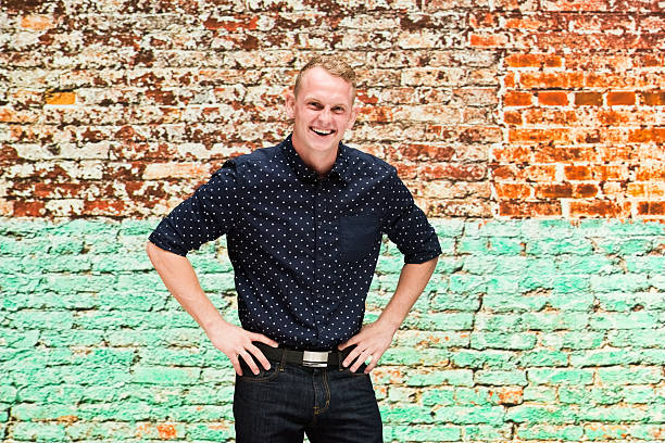 istock Smiling man in front of brick wall 622800278