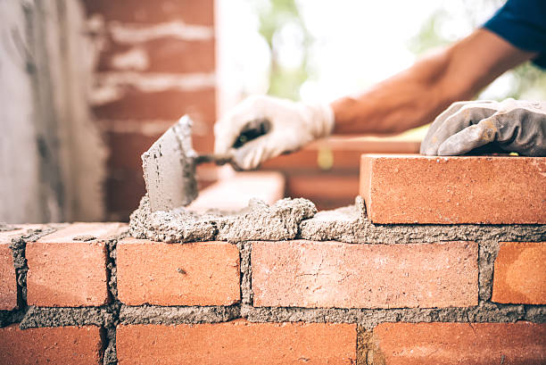 bricklayer worker installing brick masonry on exterior wall - murare bildbanksfoton och bilder