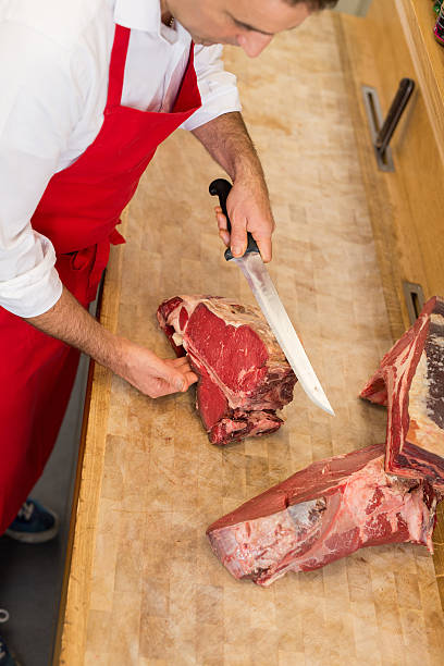 istock Butcher Cutting Meat At Counter high angle 622800874