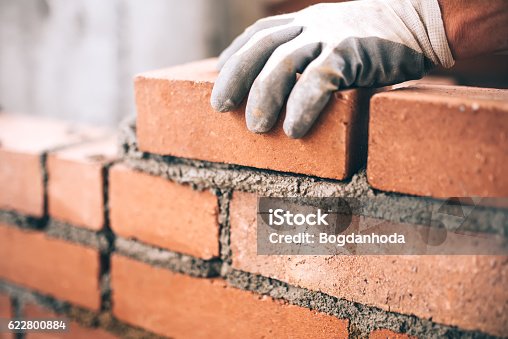 istock Close up of industrial bricklayer installing bricks on construction site 622800884