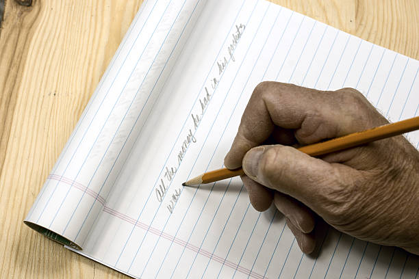 istock An author beginning his manuscript with pencil and pad 622801070