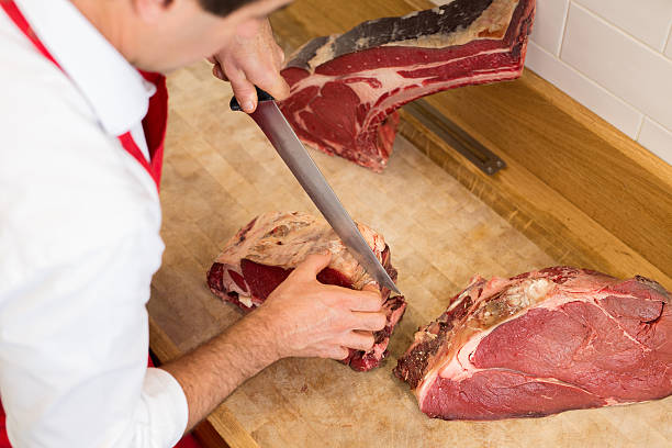 istock Butcher Cutting Meat At Counter high angle 622801724