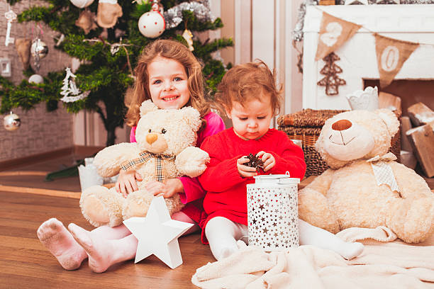 Happy pretty sisters sitting in Christmas decorated room