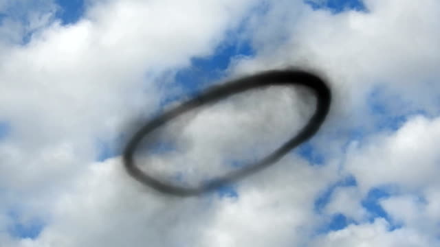 Кольцами облаками там и тут. Кольцо воздуха. Кольца дыма в воздухе. Черное дымовое кольцо в небе. Кольцо облако.