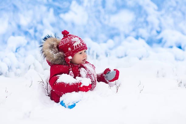 istock Baby playing with snow in winter. 622892972