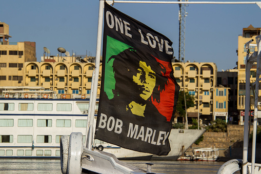 Aswan, Egypt - July 21, 2016:  A ferry carries passengers along the Nile River with a Bob Marley banner displayed on the bow.