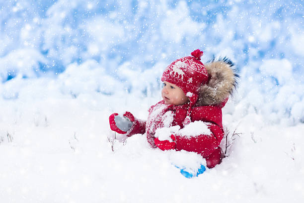 istock Baby catching snowflakes in winter park 622897402