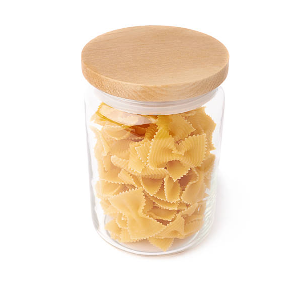 istock Glass jar filled with dry farfalle pasta over isolated white 622898760