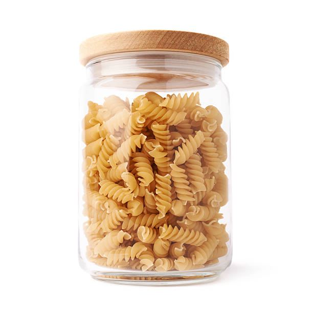 istock Glass jar filled with dry rotini pasta over isolated white 622900218