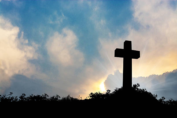 istock Silhouette the cross over blurred sunset background. 622900510