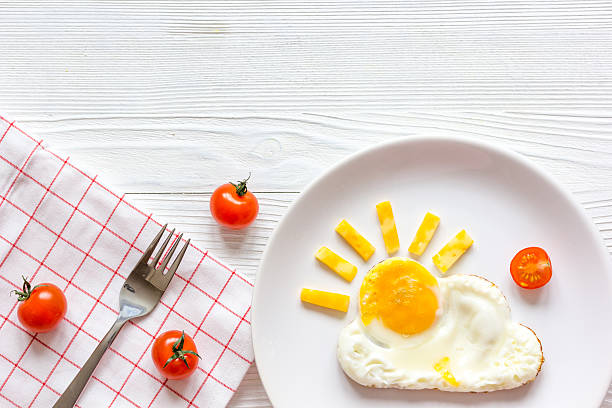 sunshine fried eggs breakfast for kid on wooden background