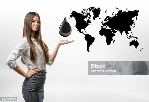 Beautiful Businesswoman Standing With Big Oil Drop Above Her Open Stock Photo - Download Image Now