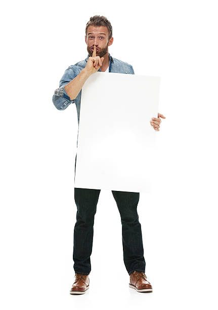 istock Man doing the be quiet sign with placard 622910304