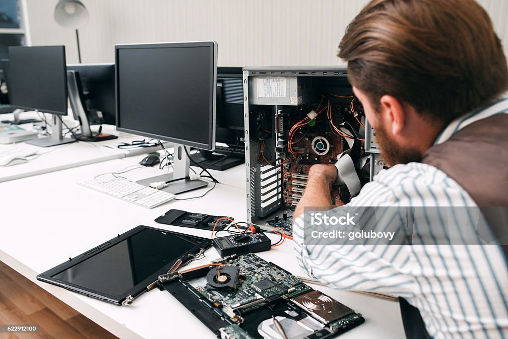 Broken computer disassembling, close-up Broken computer disassembling, close-up. Repairman take apart CPU to find failure reason. Electronic repair, renovation concept Repairing Stock Photo