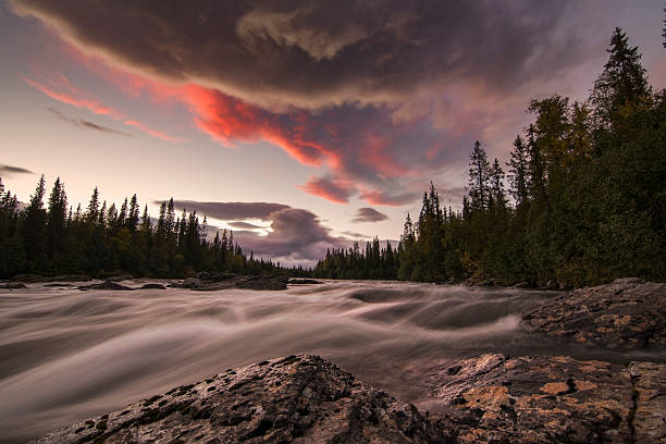 istock Dramatic river scene with storm clouds orange lid by sunset 622914900