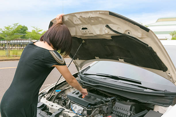 istock Young woman checking with repairing her broken car. 622916480