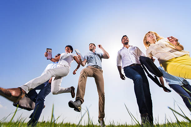 istock Group of business people running against clear sky. 622917534