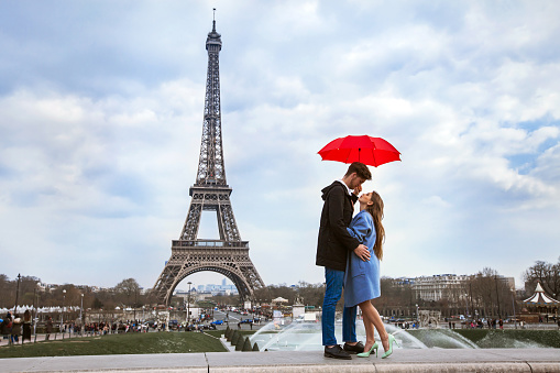 beautiful couple with umbrella near Eiffel Tower, honeymoon in Paris, romantic moment