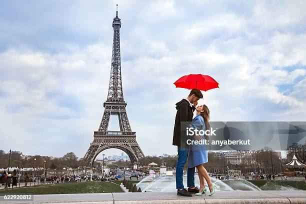 Couple With Umbrella Near Eiffel Tower Honeymoon In Paris Stock Photo - Download Image Now