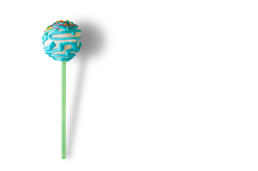 Candy with blue icing. Cake lollipop on white background. Dessert for a kid. Take small bite of happiness.