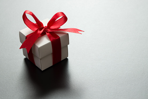 White gift box on grey background, with copy space