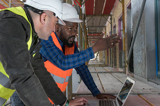 dois trabalhadores da construção civil, um afro-americano e um branco - hardhat equipment installing work tool - fotografias e filmes do acervo