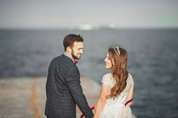 istock Just married wedding couple walking on the beach at sunset. 622923780