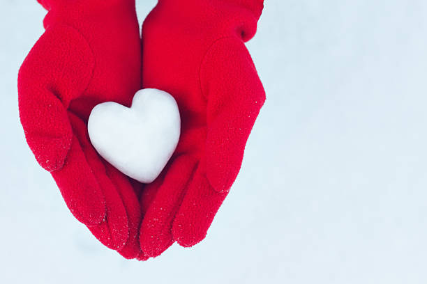 istock Heart from snow in hands on winter background 622924228