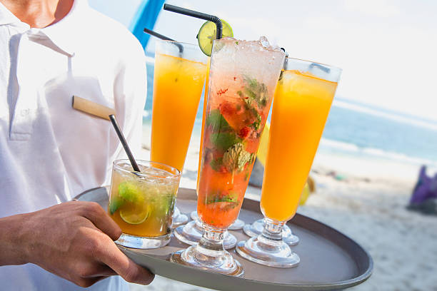 istock Young waiter holding fruit juices on the beach 622924916