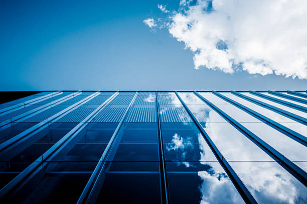 Clouds reflected in windows of modern office building stock photo