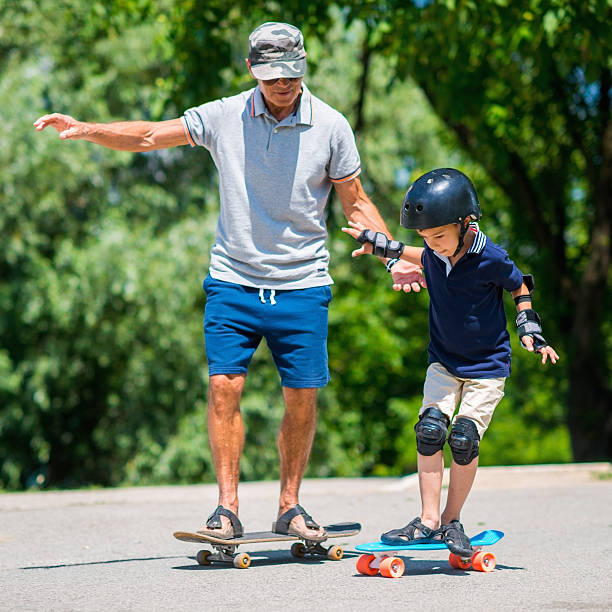 istock Grandfather and grandson skateboarding together 622927228