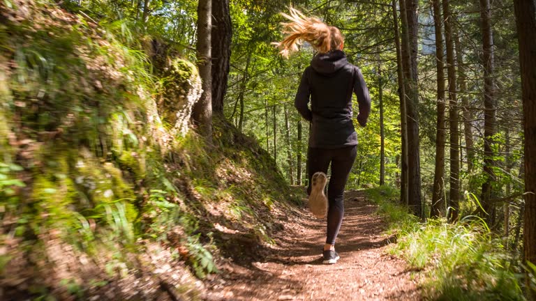 Young woman running through the woods