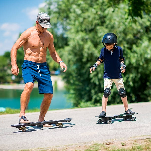 istock Senior man and little boy riding snakeboards 622954350