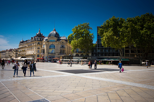 Montpellier, France - August 5, 2015: Plaza de la Comedia in Montpellier France with tourists walking across the plaza.