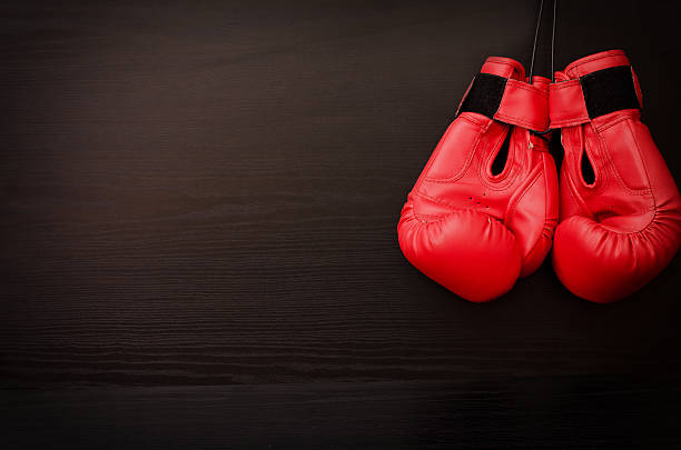 istock Two red boxing gloves hanging on a black background 622957730
