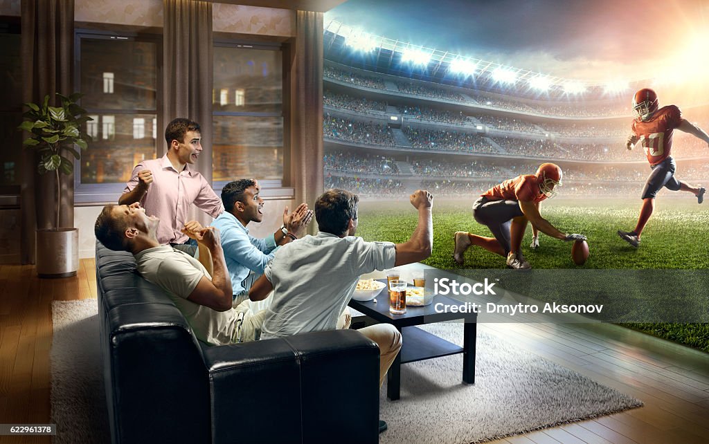 Estudantes assistindo jogo de futebol americano muito realista em casa - Foto de stock de Futebol Americano royalty-free