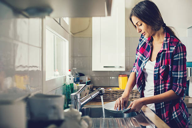 istock Young woman washing dishes 622963892