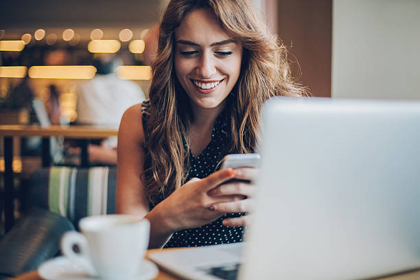 Smiling girl texting in cafe
