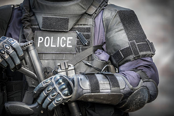 SWAT Police Officer Against Brick Wall SWAT Police Officer Against Brick Wall elbow pad stock pictures, royalty-free photos & images