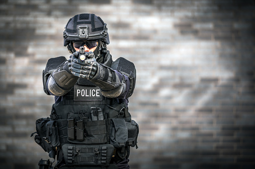 SWAT Police Officer Against Brick Wall