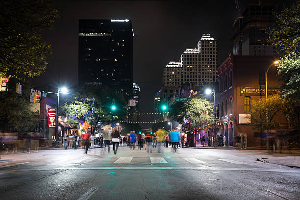 Downtown Austin at Night on Sixth Avenue, Texas, USA. People are walking while the street is closed for cars at night.