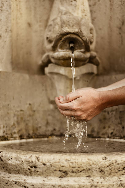 istock Hands cupping water to drink from fountain in Rome 622971146