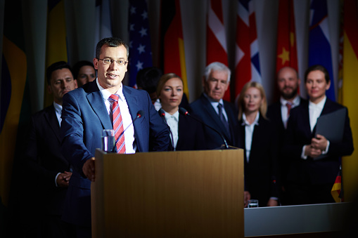 NATO OTAN Concept with NATO Flag in a Row with a Empty Wooden Wall. Press Conference in Government Building. 3D Render