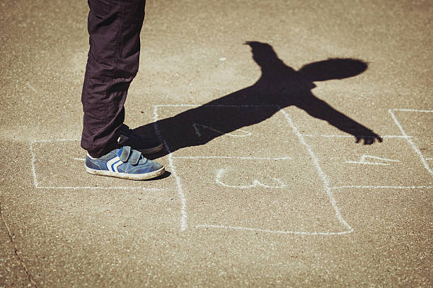 istock kid playing hopscotch on playground 622976260